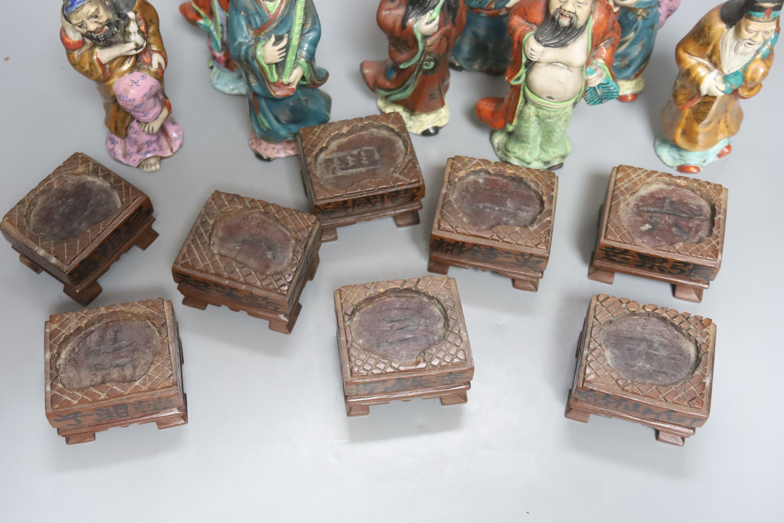 A set of eight 20th century Chinese porcelain figures of immortals, 15cm, each on carved wood stand